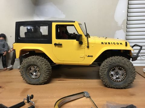 1989 Ford Bronco - This yellow Jeep Wrangler Rubicon features prominent "Rubicon" and "Jeep" badging on its side.