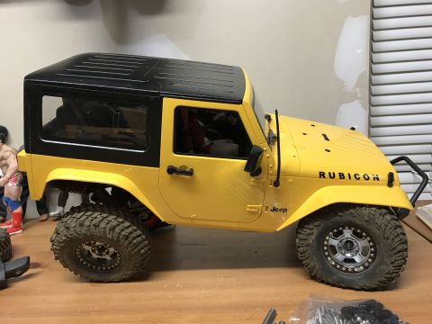1989 Ford Bronco - This is a yellow Jeep Wrangler Rubicon with a black hardtop, seen from the side.