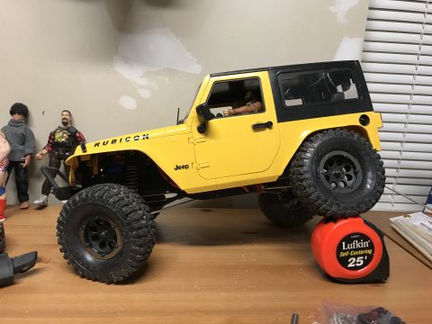 1989 Ford Bronco - A remote-controlled Jeep Wrangler Rubicon is positioned on a table, with a tape measure supporting its front wheel.