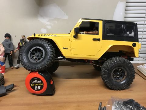1989 Ford Bronco - A yellow Jeep Wrangler Rubicon model is shown from the front driver's side, resting on a tape measure.