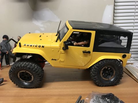 1989 Ford Bronco - This yellow Jeep Wrangler Rubicon features a black hardtop and prominent Rubicon badging on the hood.