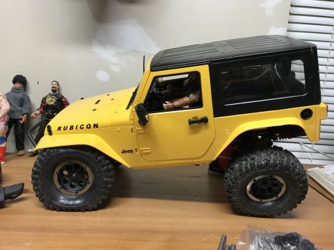 1989 Ford Bronco - RC Jeep Wrangler with Rubicon badging is shown from the side, with figures in the background.