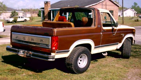 Brown and white 1980 Ford Bronco, rear three-quarter view, with top removed