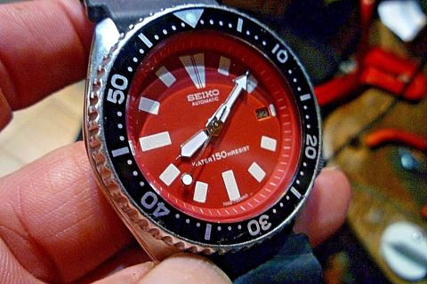 2000 Ford Crown Victoria - Close-up of a red-faced Seiko automatic watch with a black bezel and strap.