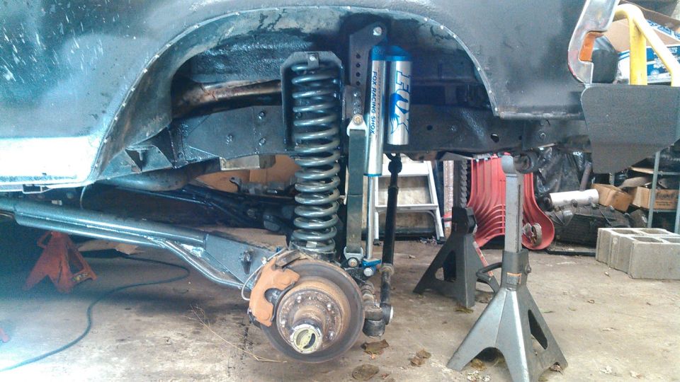 Vehicle front suspension with Fox Racing shocks and coil spring, jack stands supporting the frame