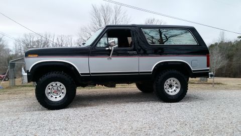 1986 Ford Bronco - This two-tone Ford Bronco is shown from the side, aftermarket wheels and a lifted suspension.