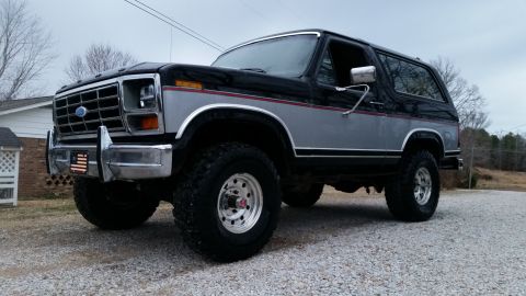 1986 Ford Bronco - This 1980s Ford Bronco features a two-tone paint scheme and large off-road tires.