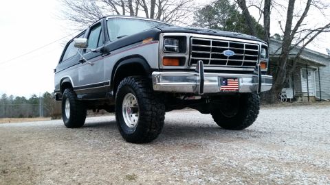 1986 Ford Bronco - This lifted Ford Bronco features a two-tone paint scheme and aggressive off-road tires, suggesting a model from the early 1980s.