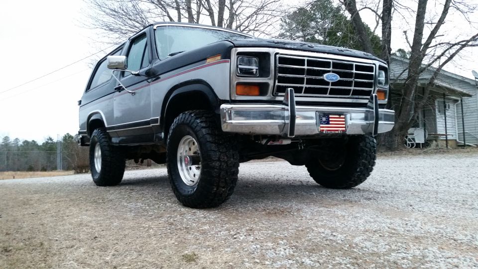 Lifted 1980s Ford Bronco, front quarter view, two-tone paint