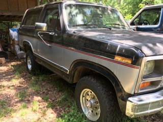 1986 Ford Bronco - This 1986 Ford Bronco is parked outside next to another vehicle.