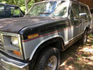 1986 Ford Bronco - This 1986 Ford Bronco is parked outdoors next to another vehicle.