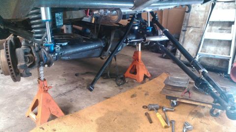 1978 Ford Bronco - Front axle assembly and suspension components are visible while the vehicle is raised on jack stands.