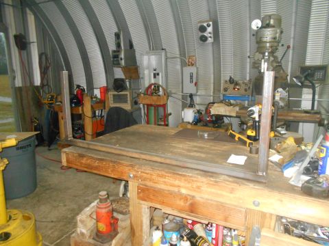 1992 Ford Bronco - A cluttered workshop scene a workbench, machinery, and storage shelves filled with tools and supplies.