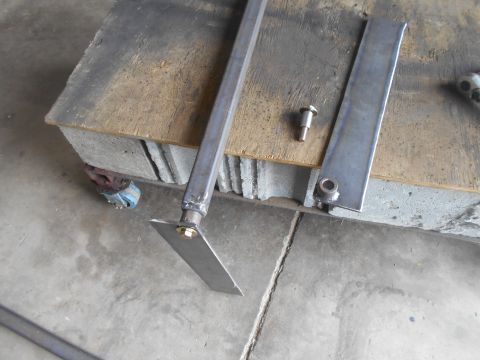 1992 Ford Bronco - Metal bracket and bolt assembly on a workbench.