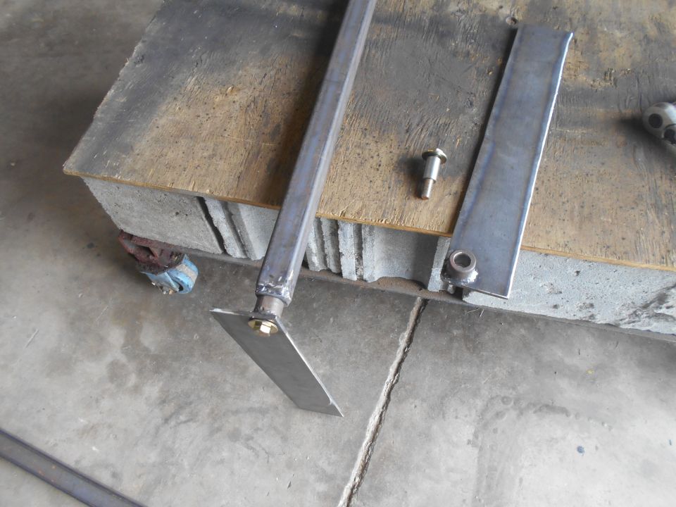 Metal bracket and bolt on a wooden surface with concrete blocks