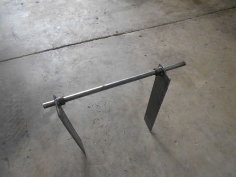 1992 Ford Bronco - A fabricated metal part consisting of a rod with two flat plates attached, resting on a concrete surface.
