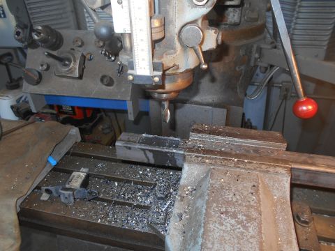 1992 Ford Bronco - A milling machine is actively cutting a metal workpiece, creating a pile of metal shavings on the table.
