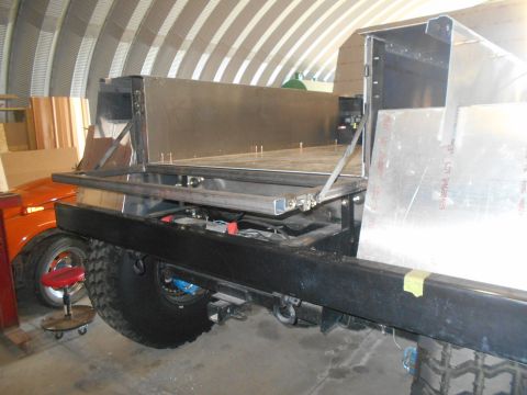 1992 Ford Bronco - Custom truck bed construction in progress, with an orange vehicle partially visible in the background.
