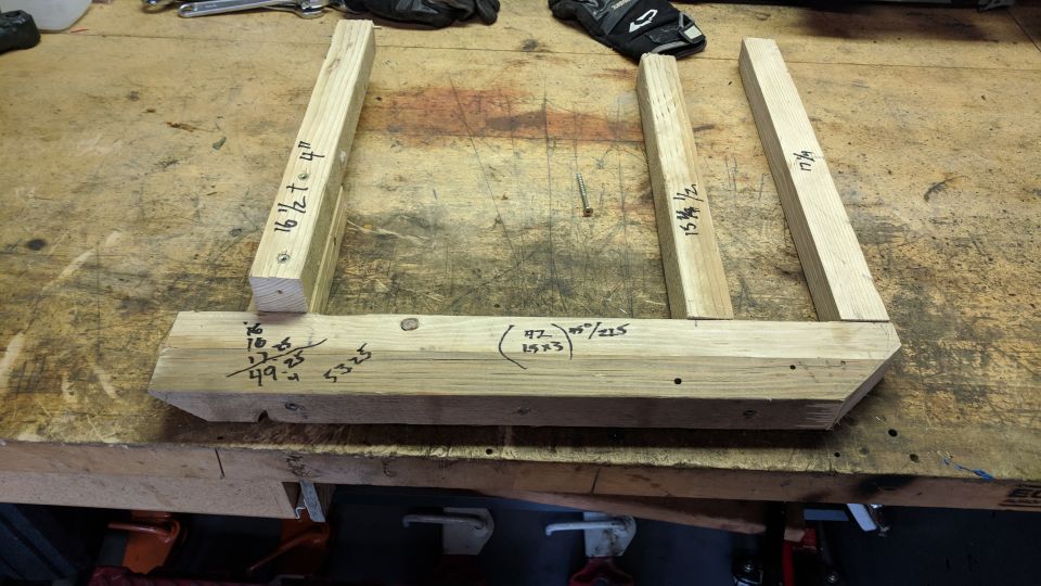 Wooden pieces with measurements on a workbench.