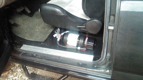 1992 Ford Bronco - The interior of a vehicle shows a fire extinguisher mounted on the floor beneath the driver's seat. The vehicle appears to be a truck or SU…