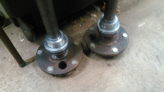 1992 Ford Bronco - Two freshly installed wheel bearings and hubs are shown resting on a concrete surface. The parts appear to be for a rear-wheel-drive vehicl…