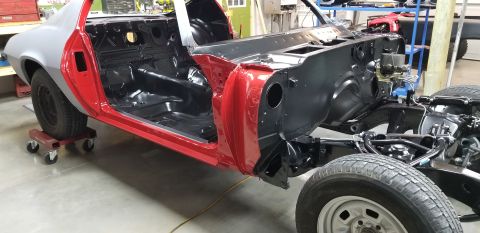 1970 Chevrolet Camaro - A partially restored 1970 Chevrolet Camaro is shown in a workshop setting. The car's interior and engine bay are visible, with red and gray…