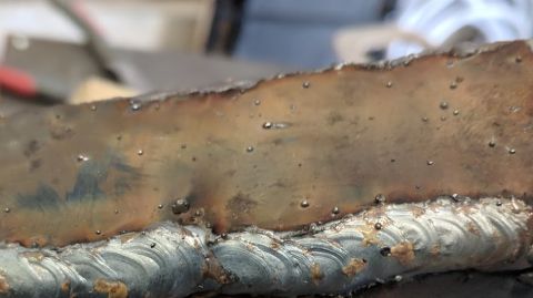 1995 Ford Bronco - A close-up shot shows a rough, metallic surface with numerous small, shiny bubbles. The surface appears to be a piece of metal that has bee…