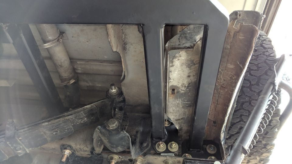 Underside of a vehicle showing suspension, exhaust pipe, and spare tire.