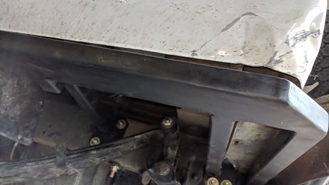 1995 Ford Bronco - The underside of a vehicle shows a black metal aftermarket bumper mounted to the rear frame. Visible components include leaf springs and su…