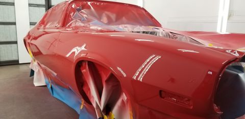 1970 Chevrolet Camaro - A bright red classic coupe, likely undergoing restoration or paint work, is covered in protective plastic sheeting on the windows and maske…
