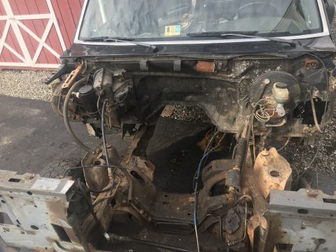 1992 Ford Bronco - Front view of a disassembled 1992 Ford Bronco, showing the engine bay with exposed frame and components. The vehicle is partially dismantle…