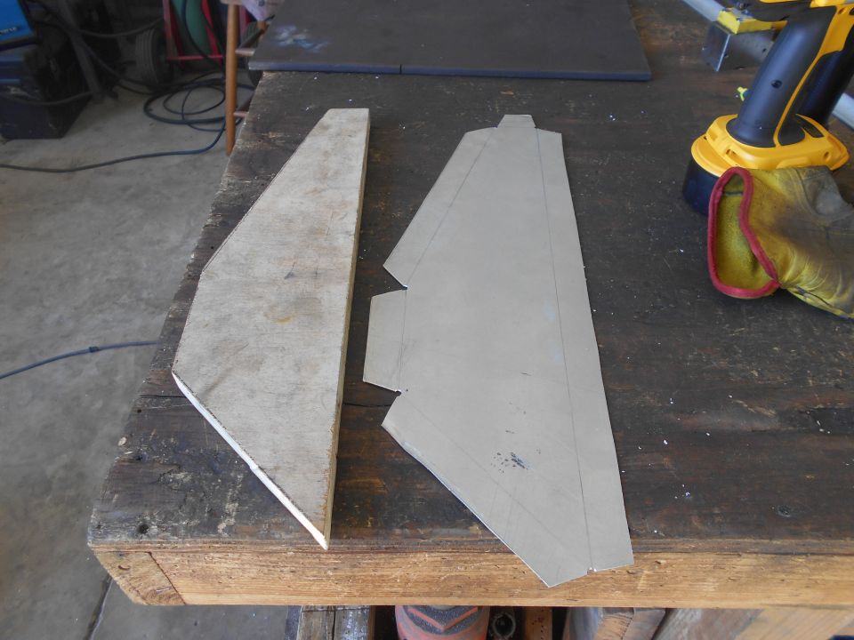 Two cut pieces of material on a workbench with a drill and glove.