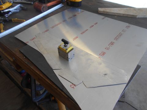 1992 Ford Bronco - A sheet of metal is being prepared for cutting on a workbench. A magnetic base with a dial indicator is positioned on the metal sheet, and…