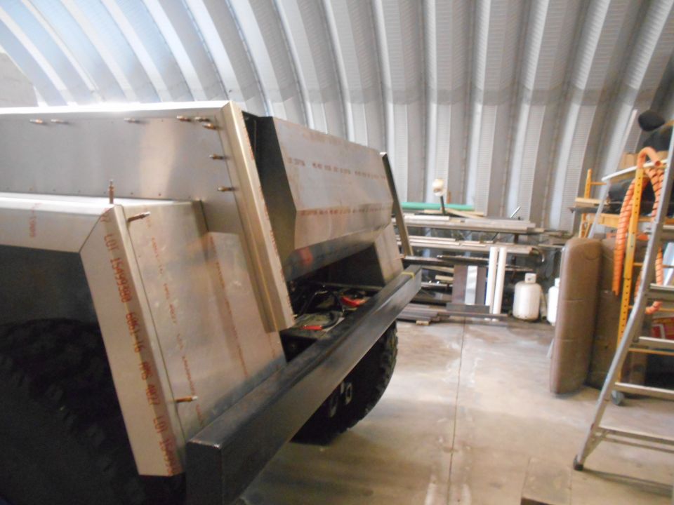 Custom metal truck bed under construction in a workshop.