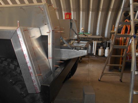 1992 Ford Bronco - A custom aluminum body is being fabricated and attached to what appears to be a large vehicle, possibly a truck or SUV, in a workshop setti…