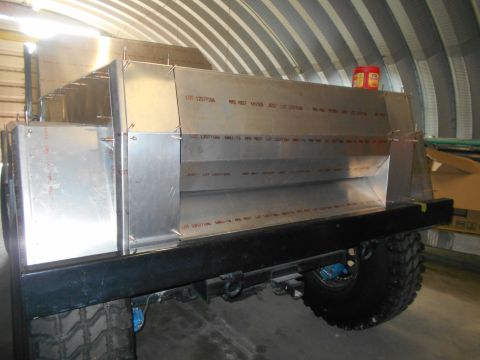 1992 Ford Bronco - Custom aluminum body panels are being assembled onto a vehicle frame in a workshop.
