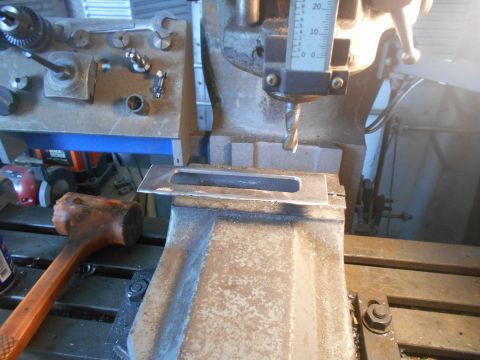 1992 Ford Bronco - A metal part is being machined on a milling machine, with a drill bit poised to cut.