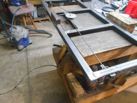 1992 Ford Bronco - Metal frame assembly with cables and pulleys, likely a custom fabrication project in a workshop.