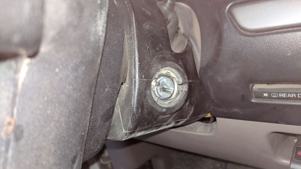 Close-up of ignition cylinder with 'REAR D' visible on dashboard
