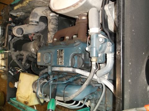 1984 Honda ATC 250 R - Close-up view of an engine, showing various hoses, pipes, and a label on the engine block.