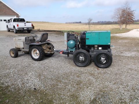 1984 Honda ATC 250 R - A garden tractor tows a large generator, with a pickup truck in the background.
