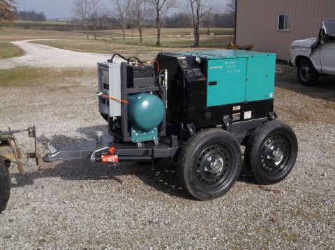 1984 Honda ATC 250 R - A portable generator unit is mounted on a trailer, with a white pickup truck in the background.