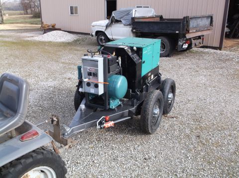 1984 Honda ATC 250 R - A generator unit is mounted on a trailer and hitched to a lawn tractor.