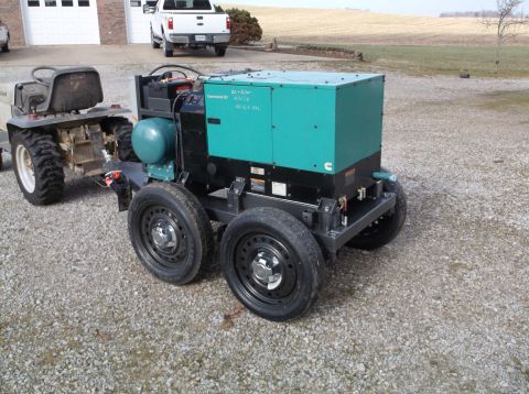 1984 Honda ATC 250 R - A portable generator unit is mounted on a trailer, with a tractor and pickup truck visible in the background.