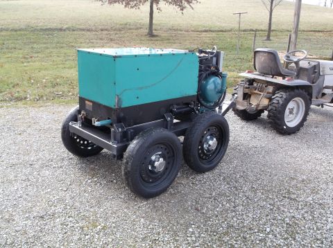 1984 Honda ATC 250 R - A generator unit is parked on a gravel surface, with a tractor visible behind it.