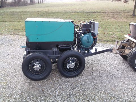 1984 Honda ATC 250 R - A trailer-mounted generator unit is hitched to the back of an ATV in an outdoor setting.