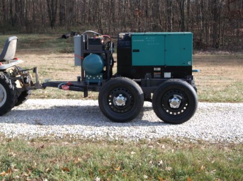 1984 Honda ATC 250 R - A portable generator unit is mounted on a trailer, connected to a small tractor.