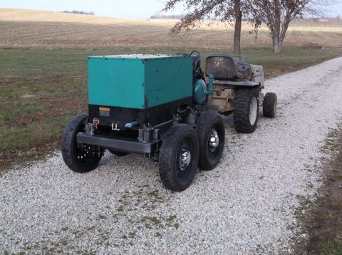 1984 Honda ATC 250 R - A custom trailer carrying a generator is towed by a tractor on a gravel road.
