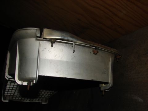1973 Ford Ranchero - A close-up view of a vehicle's headlight assembly, showing its metallic components and mounting hardware.