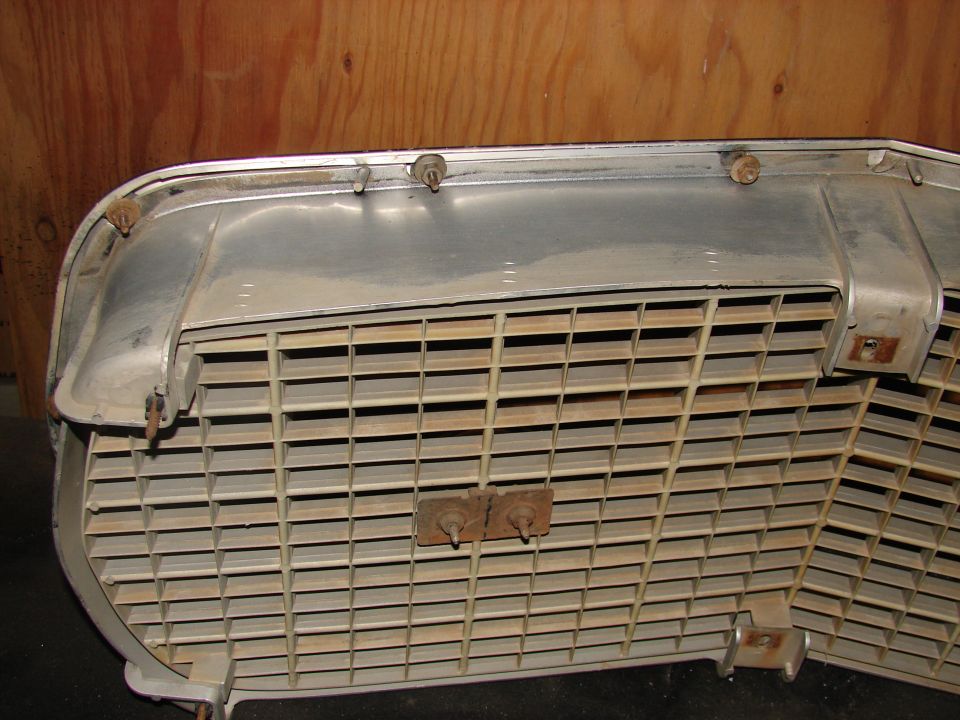 Close-up of a vehicle's front grille, showing horizontal slats and mounting hardware